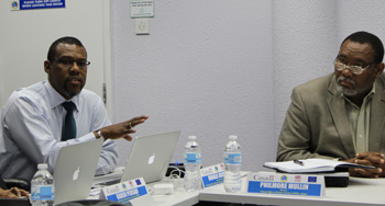 Mr Ronald Jackson, Executive Director of the Caribbean Disaster Emergency Management Agency and member of the PTRC, making his contribution to the Third PTRC meeting; while at right another member of the PTRC, Mr Philmore Mullin, Director of the National Office of Disaster Services in Antigua and Barbuda listens intently