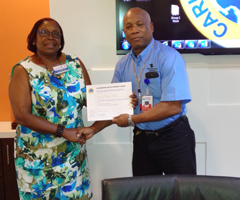 Mission Accomplished – Retired Brigadier General Earl Arthurs, Operations Specialist at CDEMA presents Certificate to Mrs. Brenda Thomas-Odlum, Director of the Community Development Division of the Government of Antigua and Barbuda. 