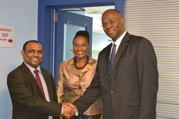 (L-R) Dr Elvis Nurse, Director , Resource Management and Administrative Division, CDEMA greets His Excellency Eugene Holiday, Governor of Sint Maarten on his arrival at the CDEMA Coordinating Unit as Ms Andria Grosvenor, Manager, Alliance and Cooperation Unit, CDEMA looks on