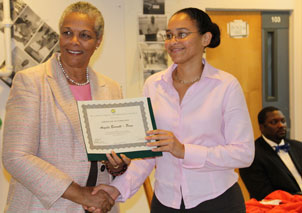 Deputy Governor V. Inez Archibald (left) presents one of the local participants, Environmental Officer at the Conservation and Fisheries Department Angela Burnett Penn, with her certificate. At right, seated at the head table, is Permanent Secretary in the Deputy Governor’s Office David Archer.