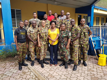 CARICOM Disaster Relief Unit (CDRU) with Superintendent St. Clair Amory (red top), Constable Ricardo Jones from the Royal Virgin Islands Police Force (grey top) and Ms. Donna Pierre of the CDEMA Coordinating Unit standing in front of the rehabilitated Alexandrina Maduro Primary School