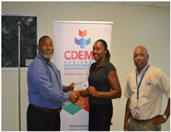 Mr. Philmore Mullin, Director of NODS, Antigua & Barbuda and Brigadier General (Rtd) Earl Arthurs, Consultant with the CDEMA CU captured above presenting a Grocery Voucher to Salome Deazle