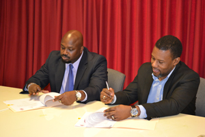 Mr.  Richard Thompson , Director General, ODPEM (L) and Mr Ronald Jackson, Executive Director, CDEMA signing the MOU at the CDEMA Coordinating Unit in Barbados